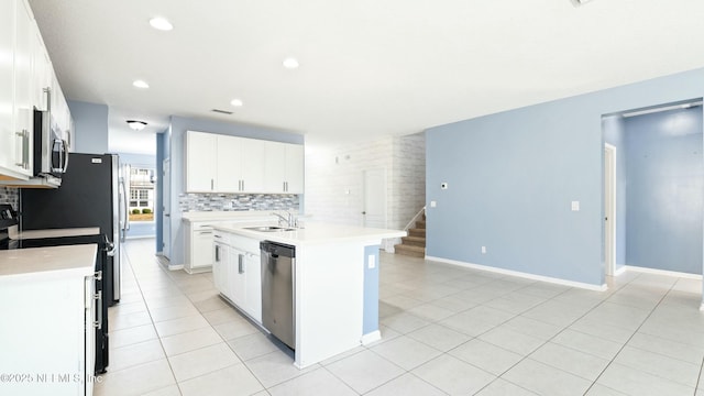 kitchen with a center island with sink, stainless steel appliances, light countertops, white cabinets, and a sink