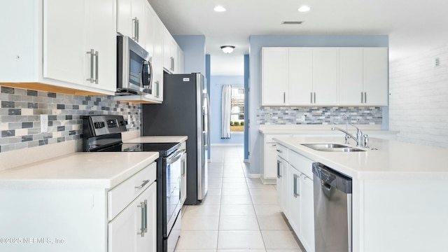 kitchen featuring light countertops, appliances with stainless steel finishes, a sink, and white cabinetry