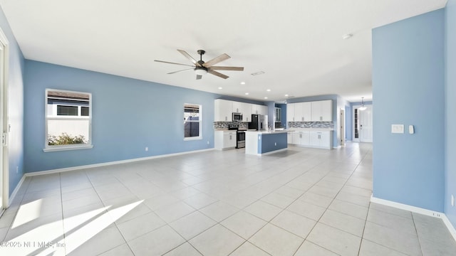 unfurnished living room with ceiling fan, recessed lighting, light tile patterned flooring, and baseboards