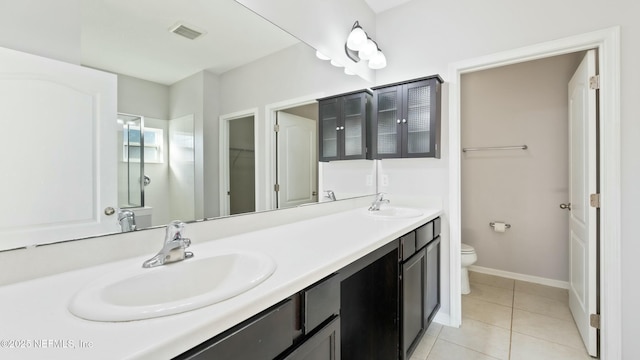 full bath with visible vents, a sink, toilet, and double vanity