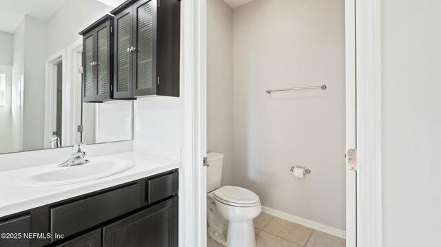 bathroom featuring tile patterned flooring, baseboards, vanity, and toilet