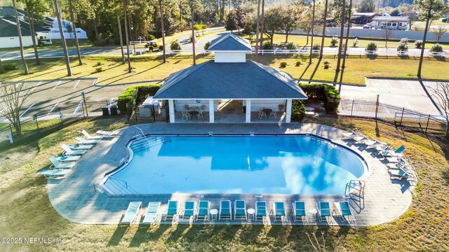 pool featuring a patio area, fence, and a lawn