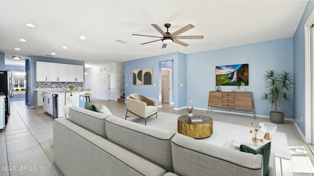 living area featuring light tile patterned flooring, recessed lighting, a ceiling fan, baseboards, and stairway