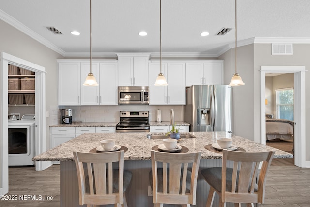 kitchen featuring light stone counters, appliances with stainless steel finishes, sink, and white cabinets