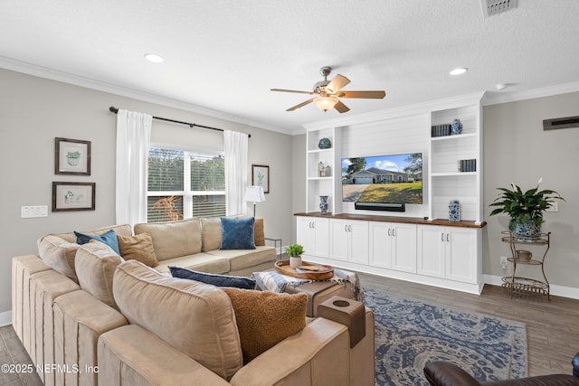 living room with dark wood-type flooring, ceiling fan, ornamental molding, and a textured ceiling