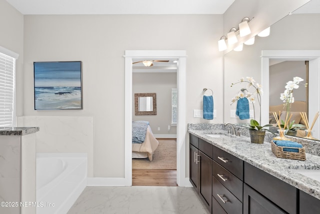 bathroom with vanity, a tub to relax in, and ceiling fan