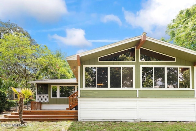 rear view of house with a sunroom and a deck