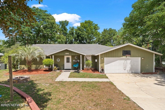 ranch-style home featuring cooling unit, a garage, and a front yard