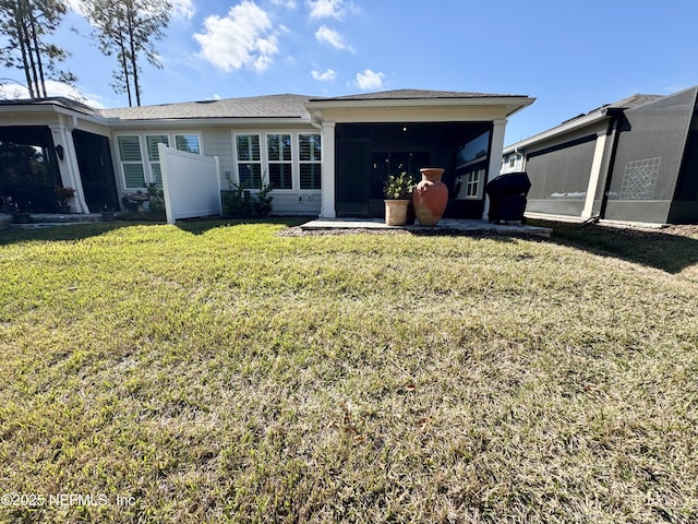 back of house with a yard and a sunroom