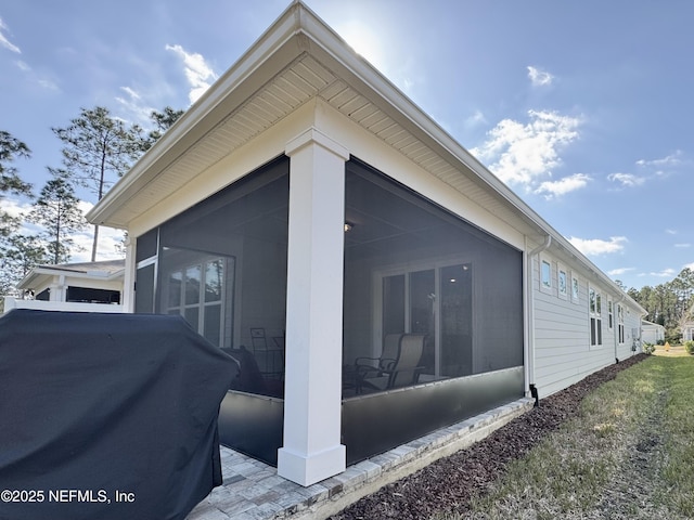 view of property exterior with a sunroom