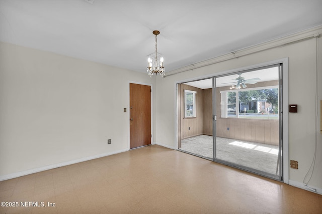 spare room with ceiling fan with notable chandelier