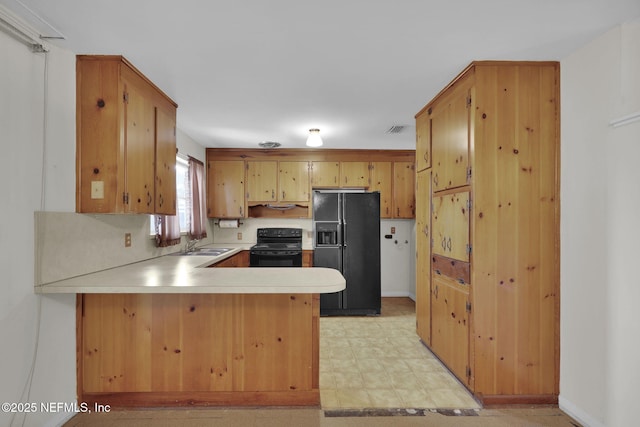 kitchen with sink, black appliances, and kitchen peninsula