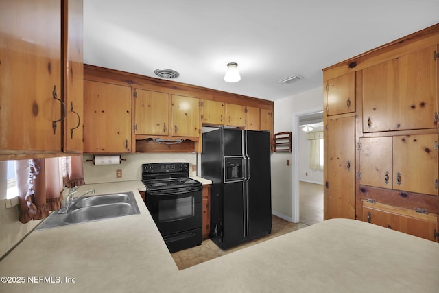 kitchen with sink, light tile patterned floors, and black appliances