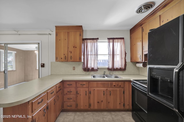 kitchen featuring sink, black appliances, and kitchen peninsula