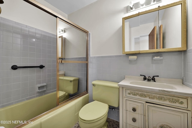 full bathroom featuring vanity, shower / bath combination with glass door, tile walls, and toilet