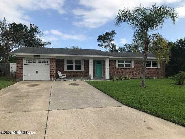 single story home featuring a garage and a front lawn