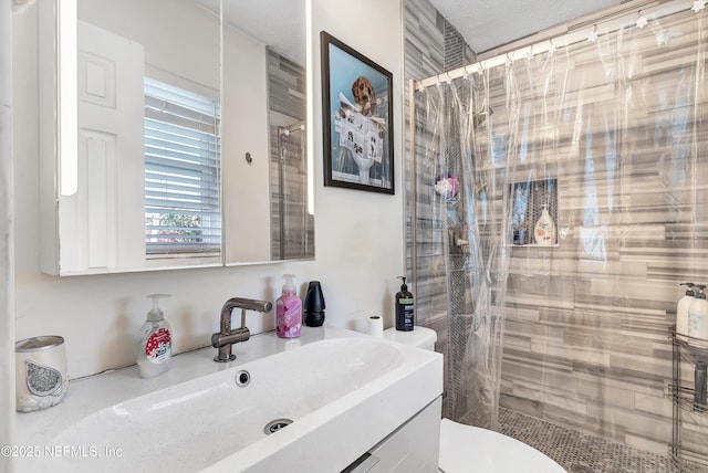 full bath featuring toilet, a shower stall, and vanity