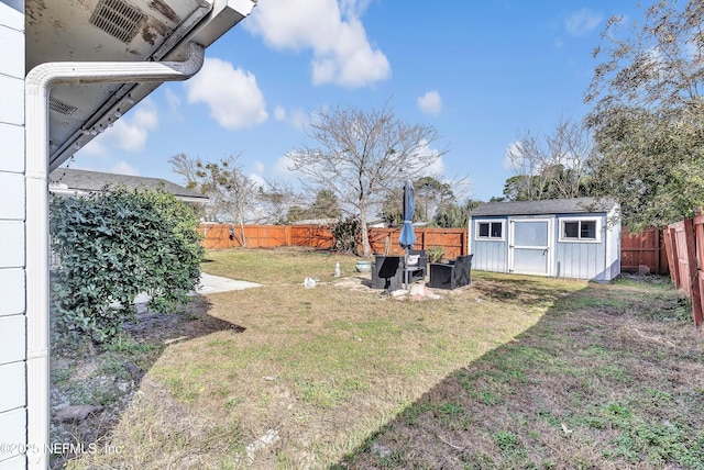 view of yard featuring an outbuilding, a fenced backyard, and a storage unit