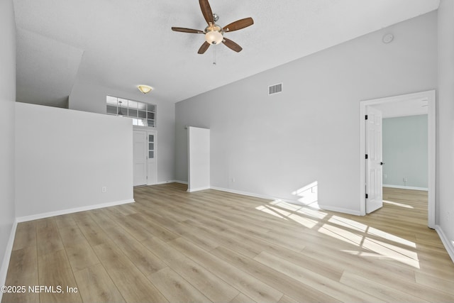 unfurnished living room with ceiling fan, light wood-type flooring, vaulted ceiling, and a textured ceiling