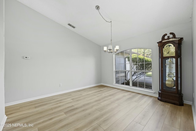 unfurnished dining area featuring lofted ceiling, a chandelier, and light hardwood / wood-style flooring