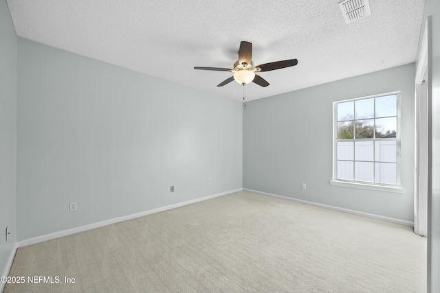 carpeted empty room with ceiling fan and a textured ceiling