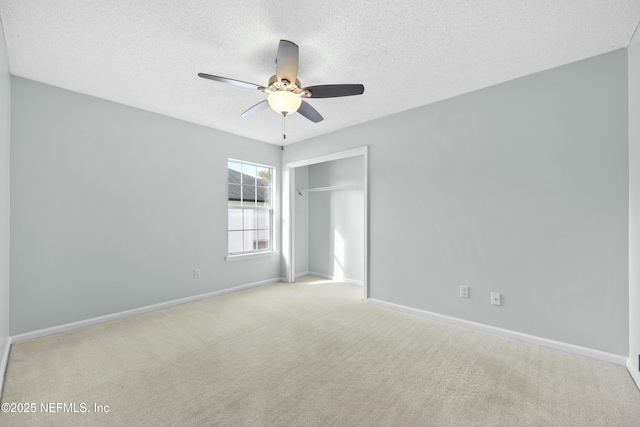 carpeted spare room featuring ceiling fan and a textured ceiling