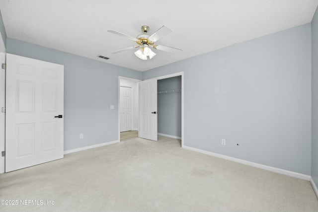 unfurnished bedroom featuring ceiling fan, a closet, and light colored carpet