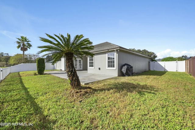 back of house featuring a patio area and a yard