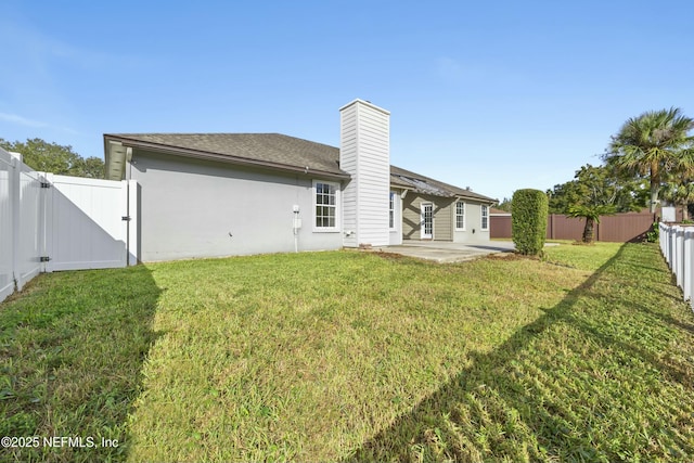 back of property with a patio area and a yard