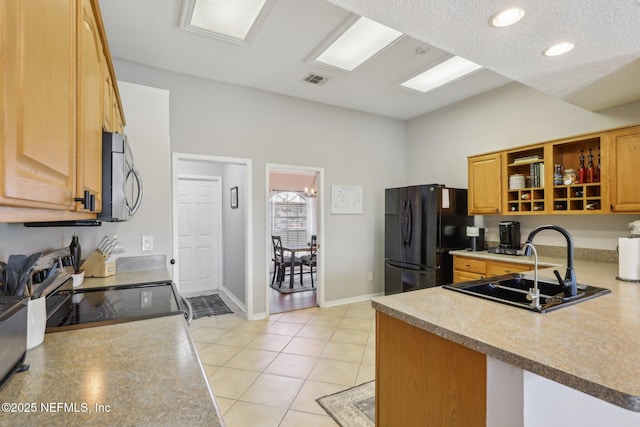 kitchen featuring appliances with stainless steel finishes, sink, light tile patterned floors, and kitchen peninsula