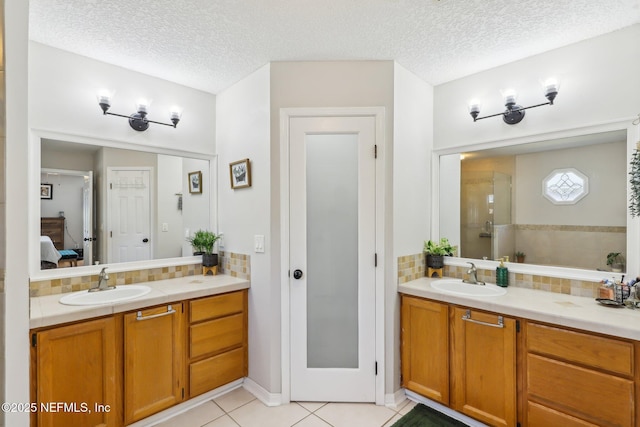 bathroom featuring vanity, a textured ceiling, decorative backsplash, tile patterned floors, and walk in shower