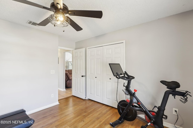 exercise room featuring hardwood / wood-style floors and a textured ceiling