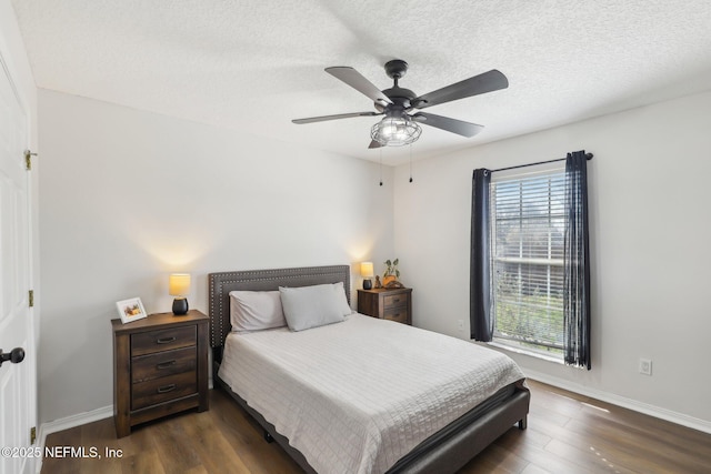 bedroom with ceiling fan, dark hardwood / wood-style floors, and a textured ceiling