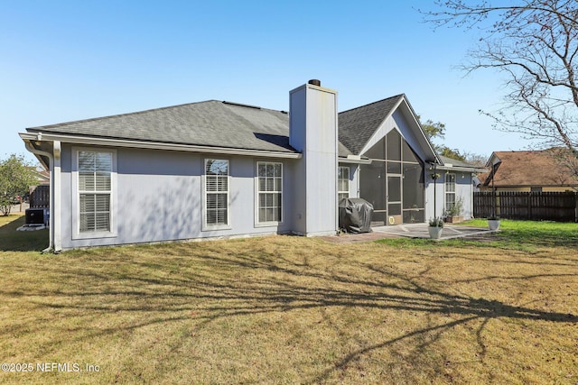 back of house featuring a sunroom, a patio area, and a lawn