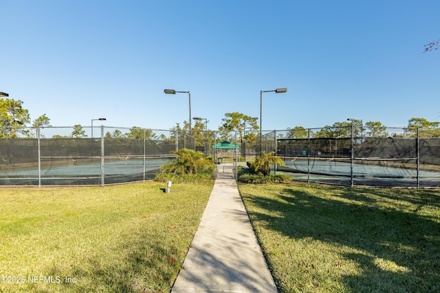 view of sport court featuring a yard