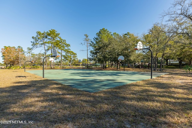 view of basketball court with a yard