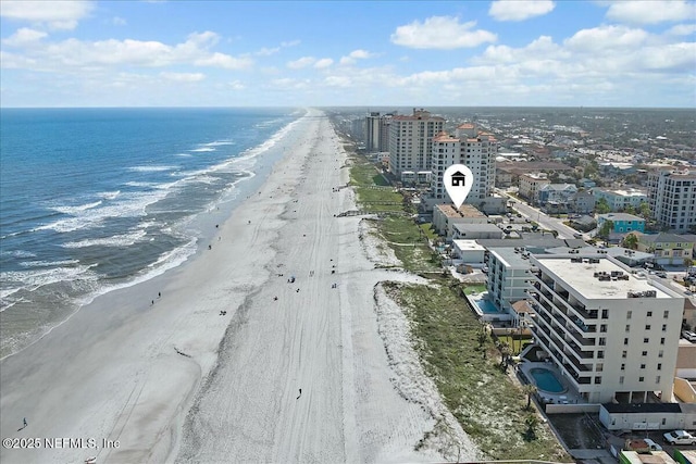 birds eye view of property with a water view and a beach view