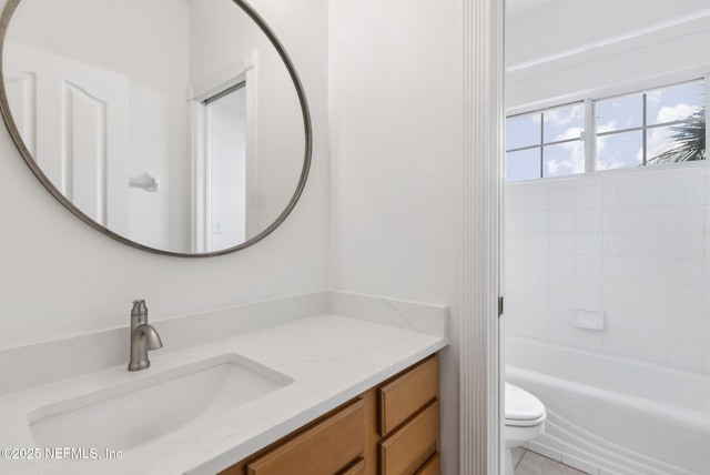 full bathroom with vanity, tiled shower / bath, and toilet