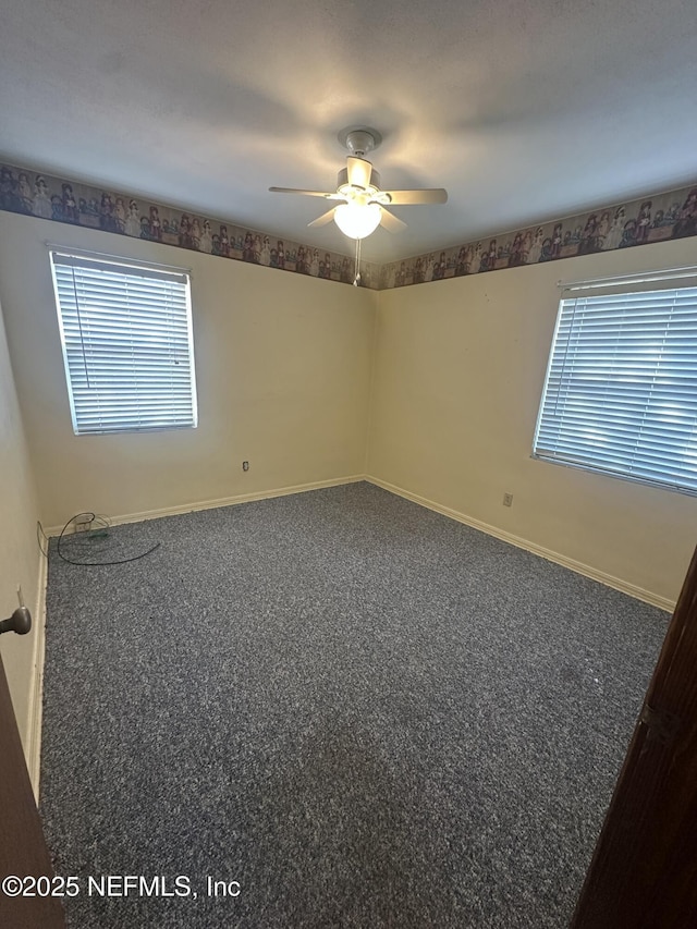 carpeted spare room featuring ceiling fan