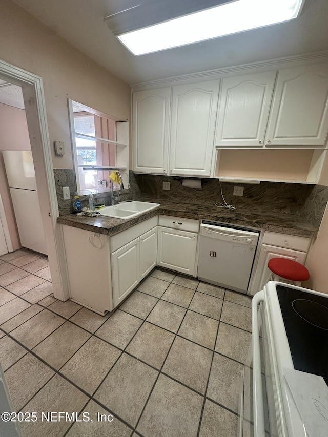 kitchen featuring sink, white appliances, tasteful backsplash, white cabinets, and light tile patterned flooring