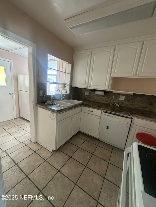 kitchen with sink, white cabinets, decorative backsplash, light tile patterned floors, and white appliances