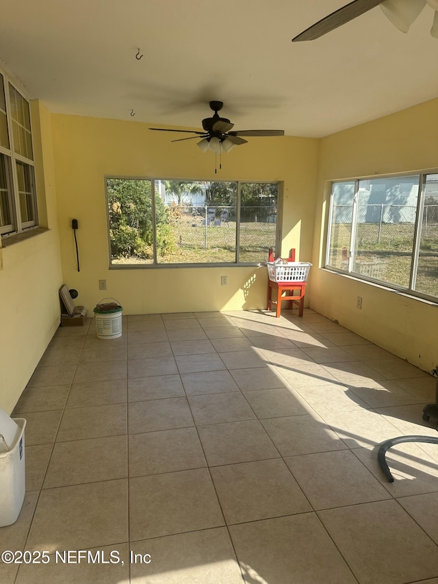 unfurnished sunroom with ceiling fan