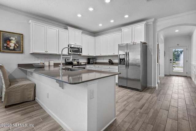 kitchen featuring white cabinetry, a kitchen breakfast bar, kitchen peninsula, and appliances with stainless steel finishes