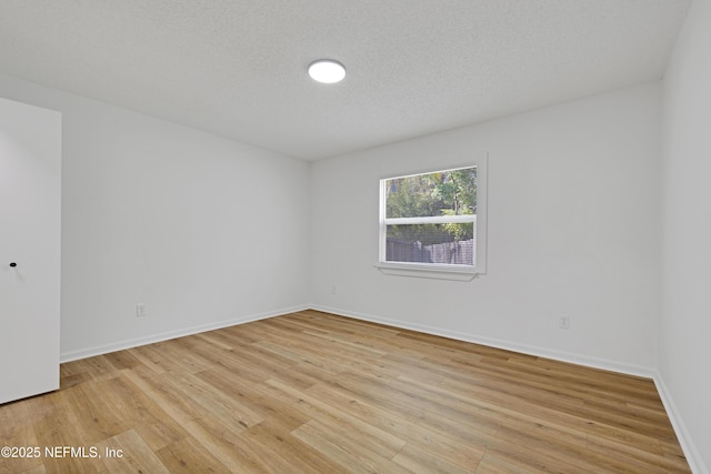 unfurnished room featuring a textured ceiling and light wood-type flooring