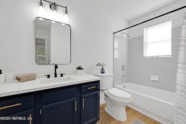 full bathroom featuring toilet, shower / tub combo, a textured ceiling, vanity, and hardwood / wood-style flooring