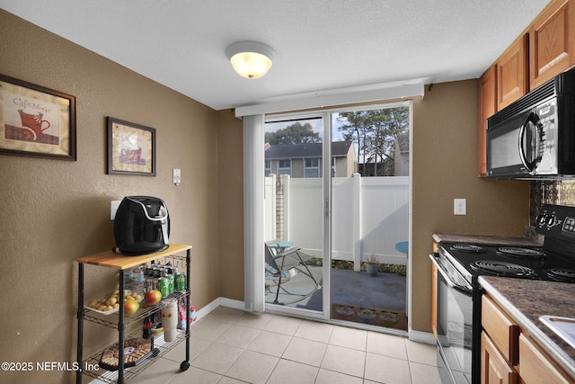 kitchen featuring black appliances, a textured ceiling, and light tile patterned flooring