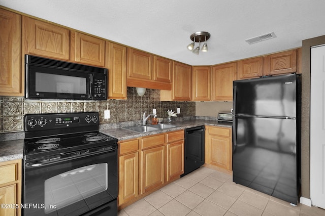 kitchen with backsplash, light tile patterned floors, sink, and black appliances