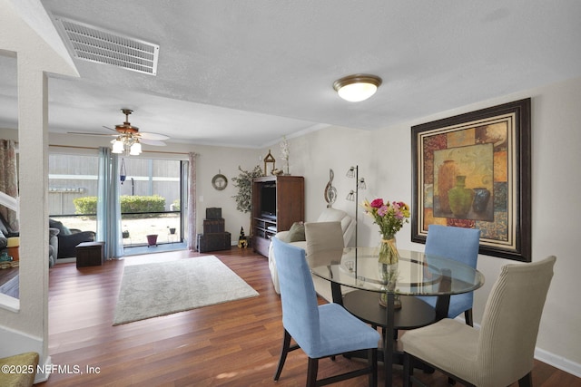 dining space with ceiling fan, dark hardwood / wood-style floors, and a textured ceiling