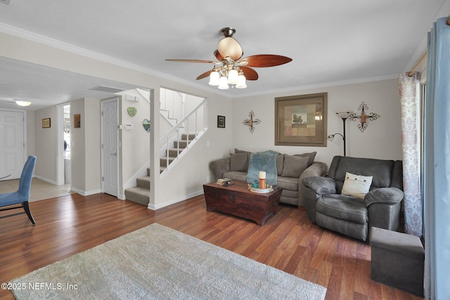 living room featuring wood-type flooring, ornamental molding, and ceiling fan