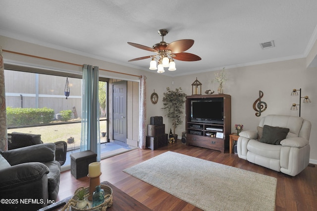 living room with dark wood-type flooring, ceiling fan, crown molding, and a textured ceiling